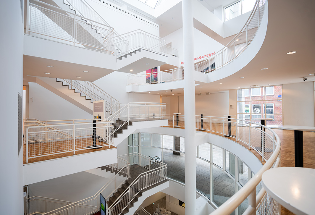 Innenansicht des Stadthauses. Blick in das helle Innere des Stadthauses Ulm mit geschwungenen Treppen und großen Glasflächen, die für eine lichtdurchflutete Atmosphäre sorgen