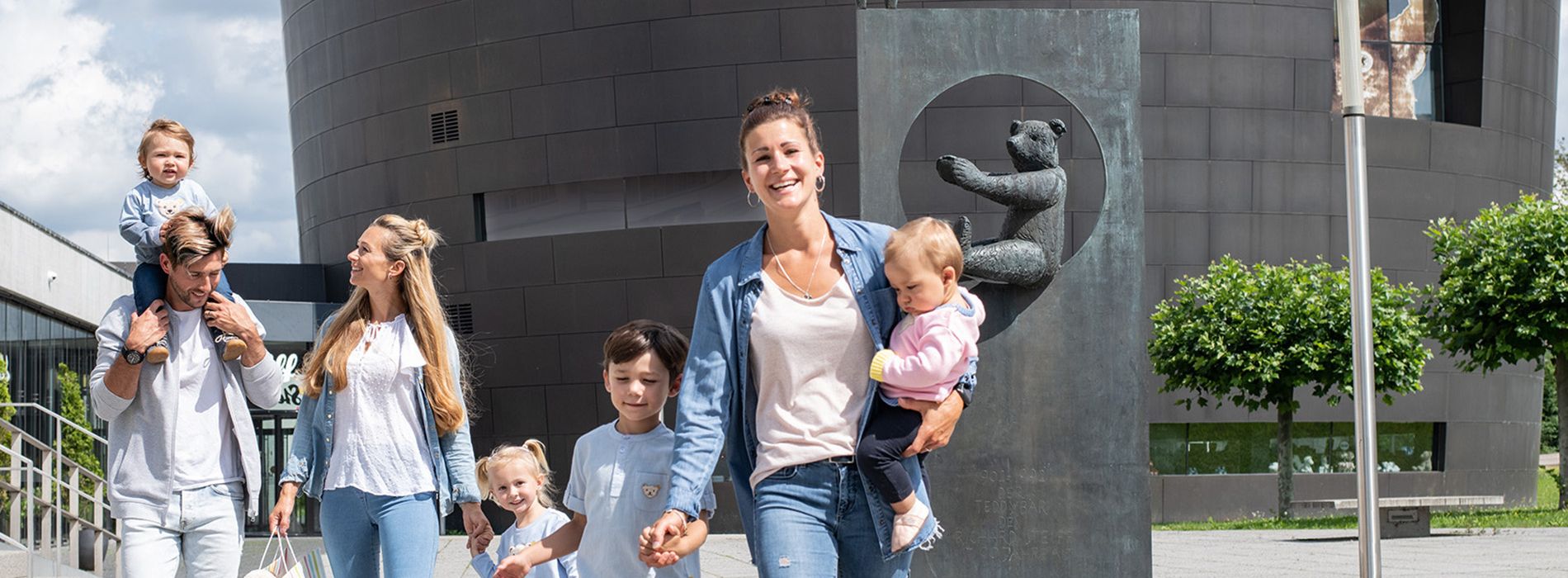 Familiengruppe mit Kindern vor dem Eingang des Steiff Museums in Giengen an der Brenz.