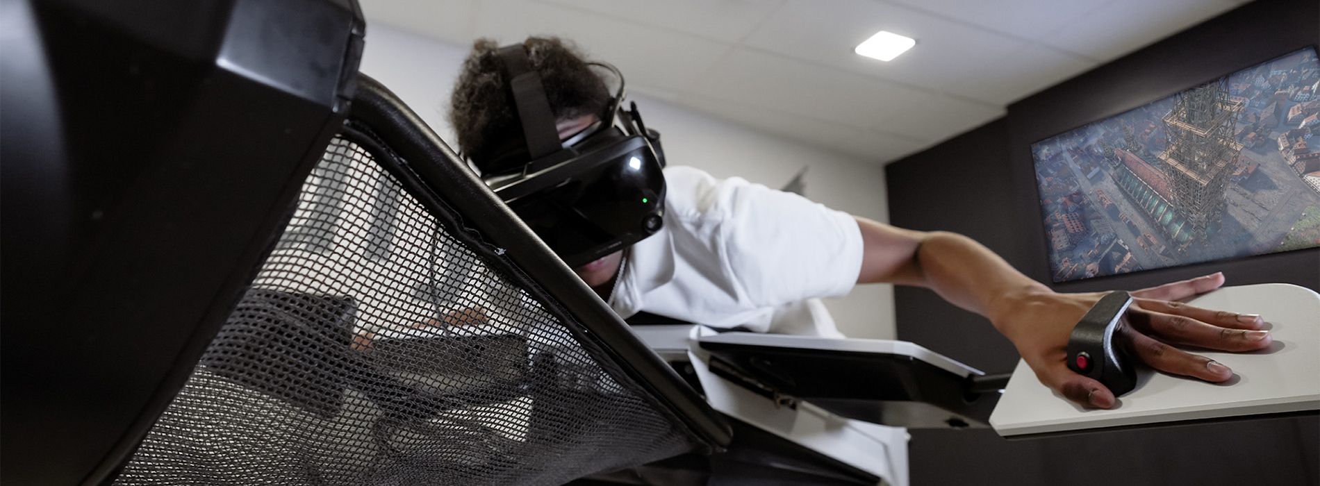 Person steuert „Birdly“-Flugsimulator mit VR-Brille und ausgestreckten Armen.